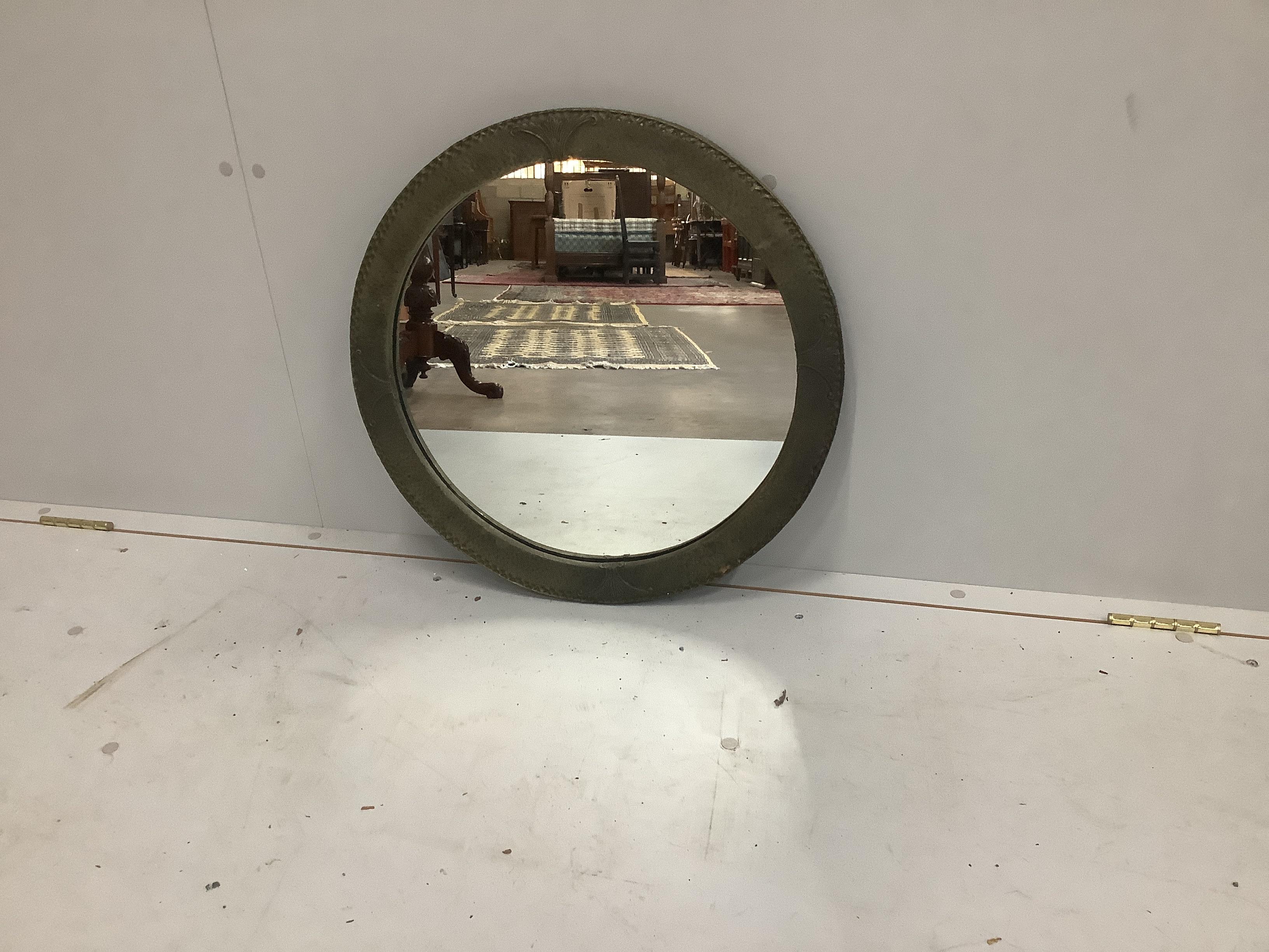 An early 20th century hammered brass framed wall mirror, diameter 54cm